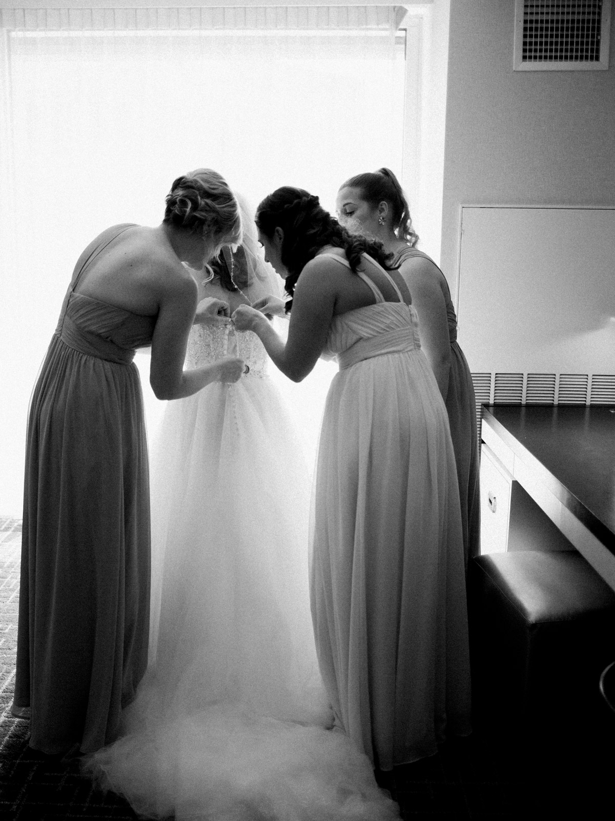 Bride puts on dress at Arlington hotel before wedding