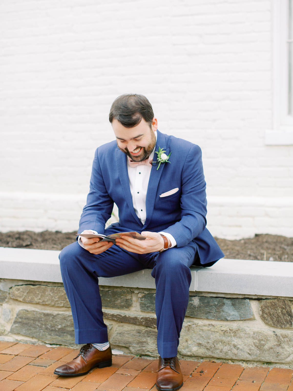 Groom reading love letter from bride on wedding day