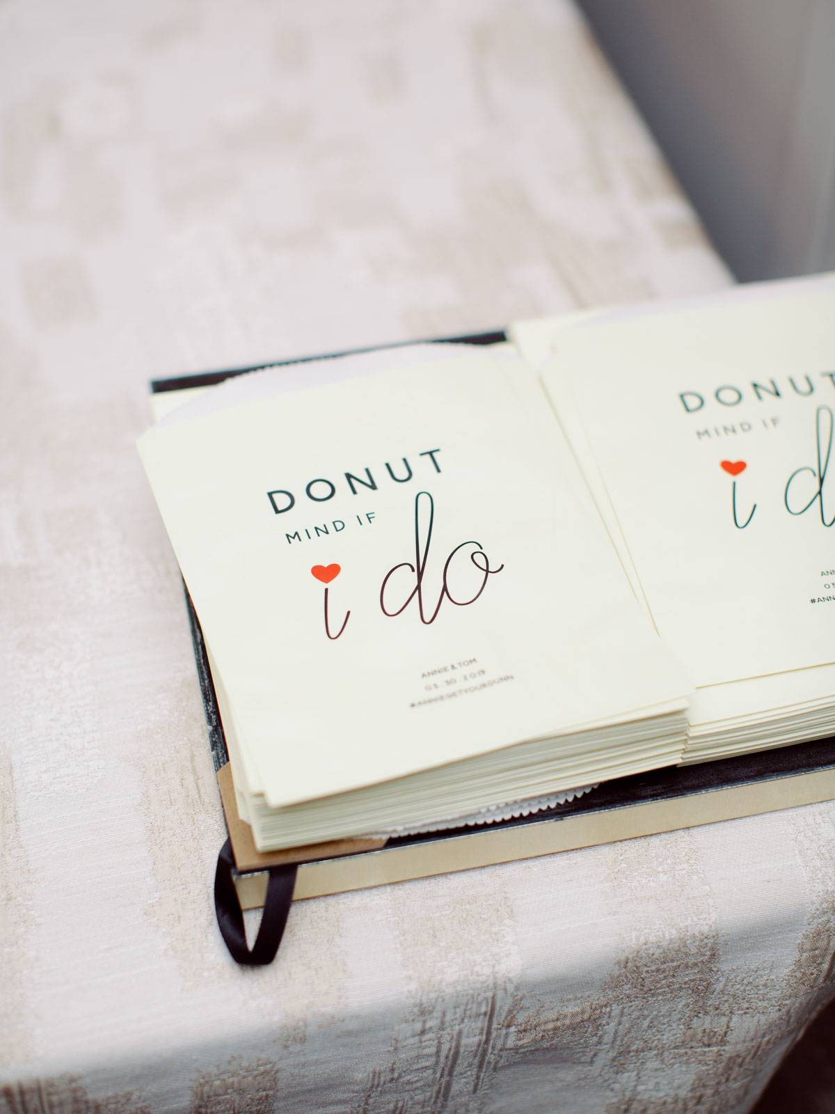 Donut dessert bar to-go bags with cute quote about the wedding couple.