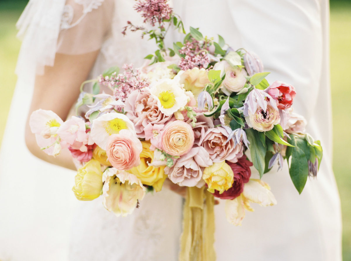 Wedding bouquet by Vintage Florals in Nashville with pops of pink, peach, yellow, and orange.