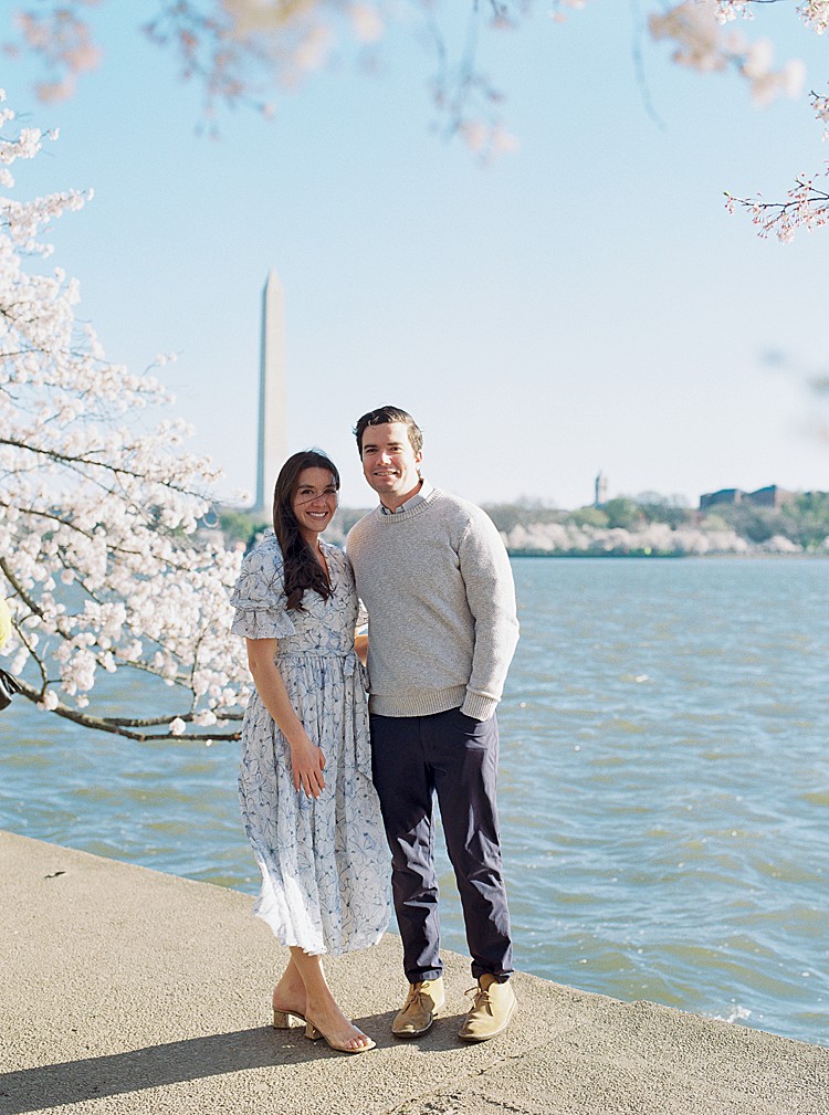 Couple poses for engagement photos at the cherry blossoms on the Tidal Basin in Washington, D.C.