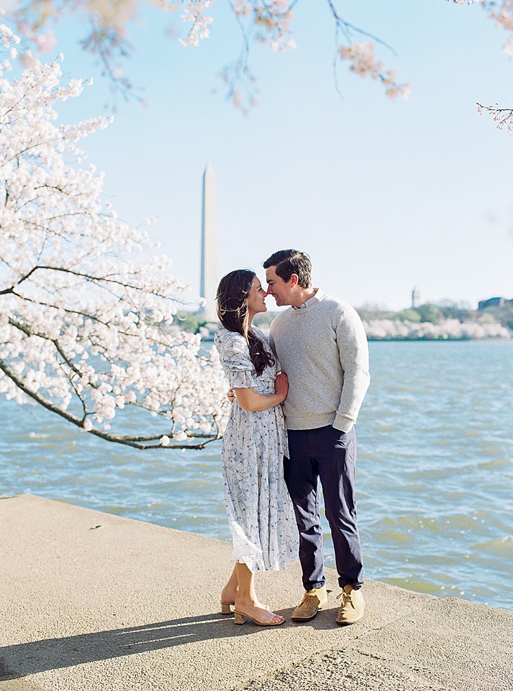 Couple poses for engagement photos at the cherry blossoms on the Tidal Basin in Washington, D.C.