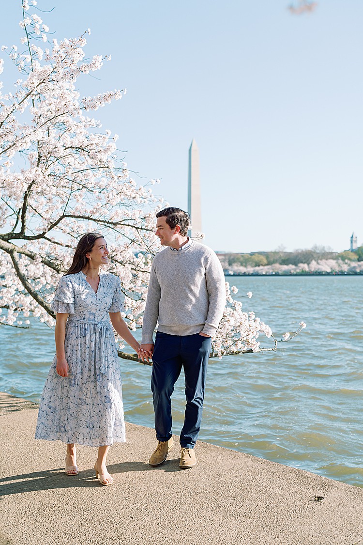 Couple poses for engagement photos at the cherry blossoms on the Tidal Basin in Washington, D.C.