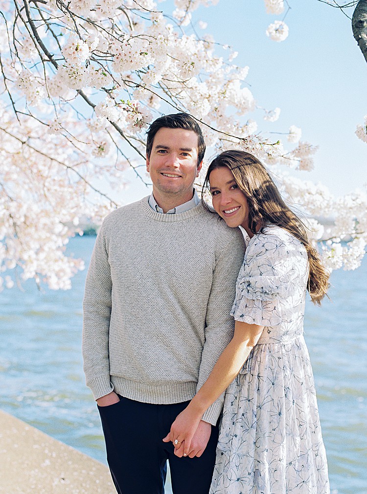 Couple poses for engagement photos at the cherry blossoms on the Tidal Basin in Washington, D.C.